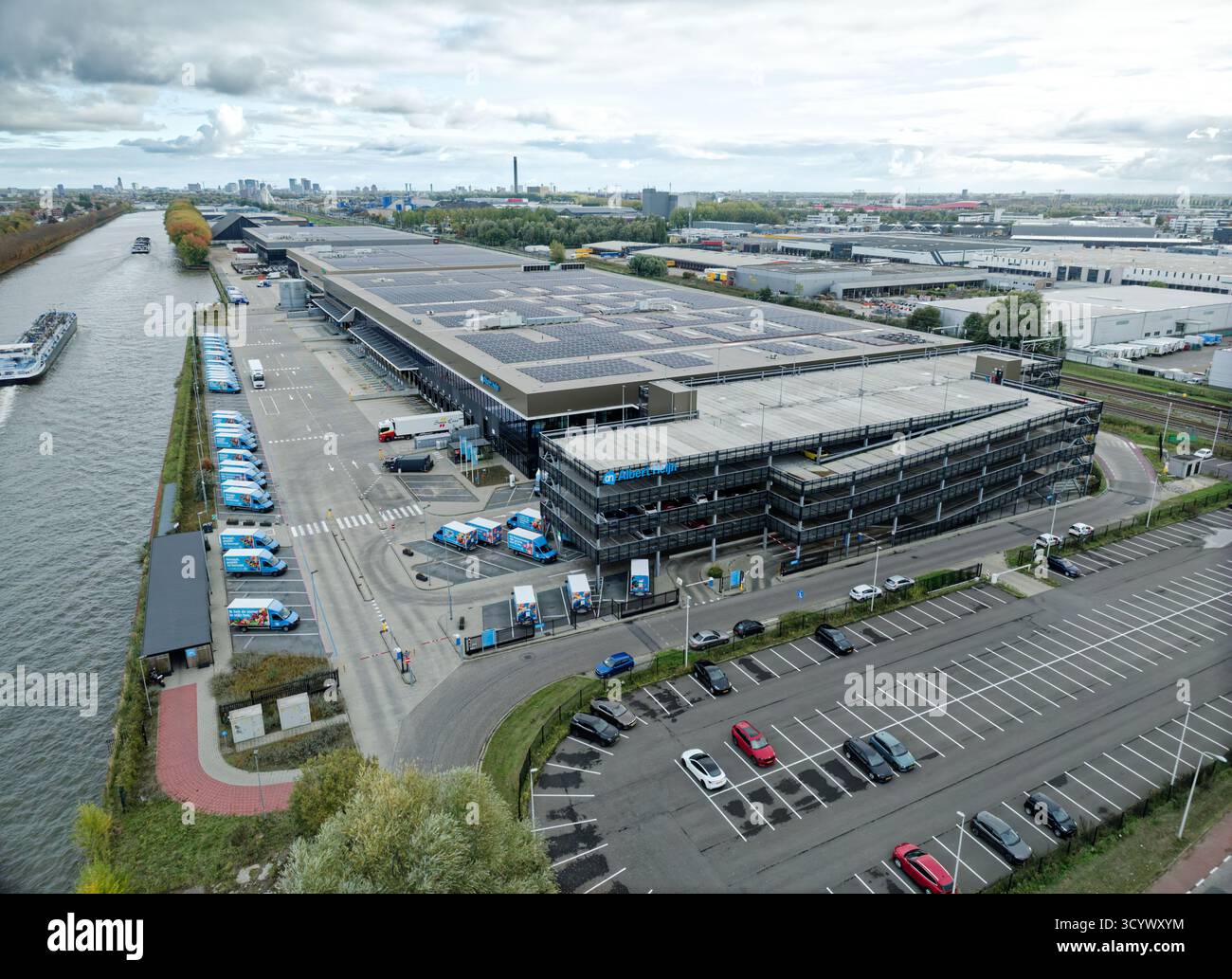 Utrecht, Paesi Bassi - 16 ottobre 2025: Centro di distribuzione aerea Albert Heijn nei Paesi Bassi con furgoni per la consegna, banchine di carico e lato canale Foto Stock