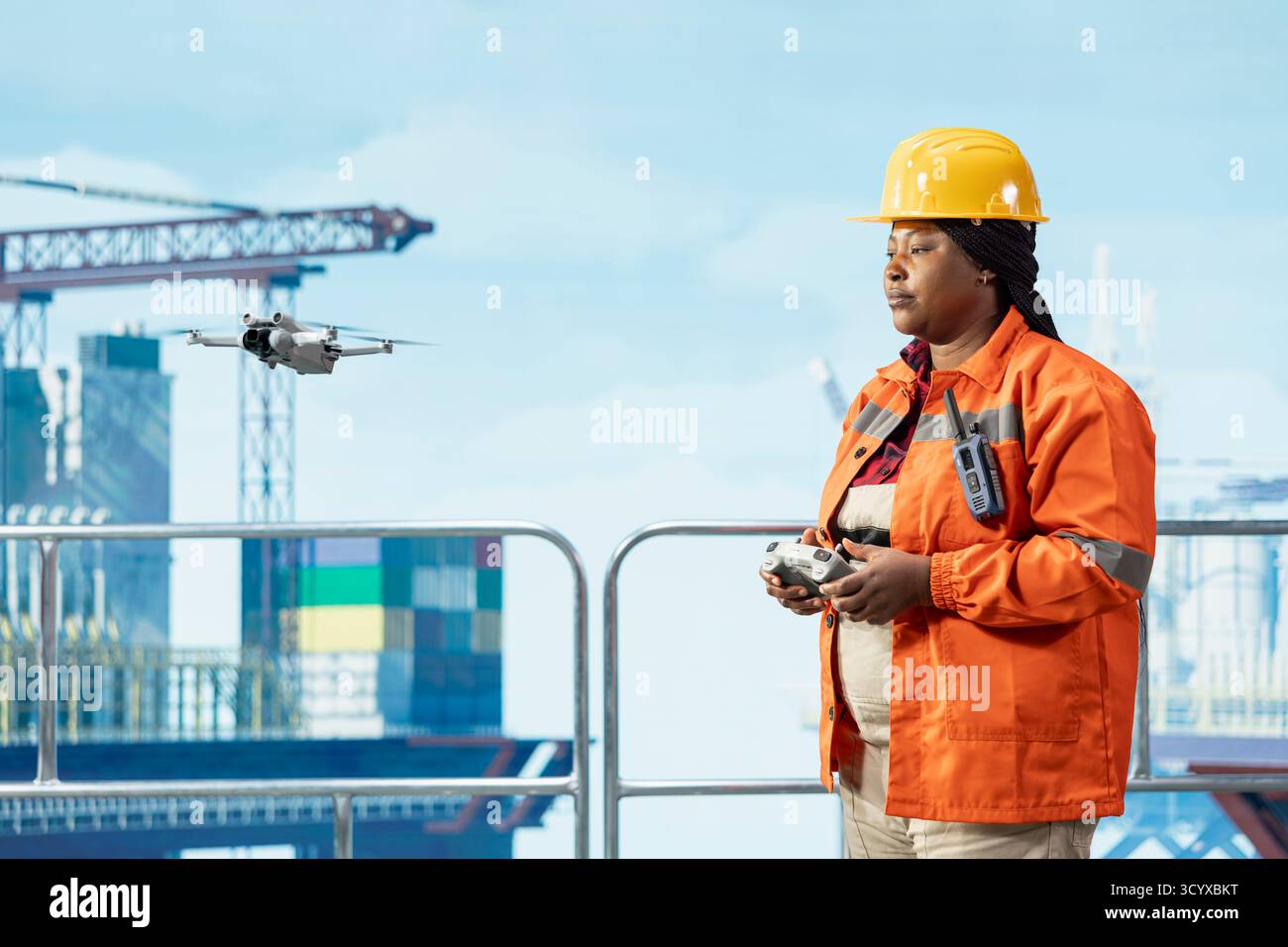 Perforare un tecnico di chiatte utilizzando un drone per accedere alle aree che presentano rischi per la sicurezza per l'uomo da una distanza di sicurezza. Una donna sul ponte piattaforma offshore utilizza un UAV a controllo remoto per condurre ispezioni aeree Foto Stock