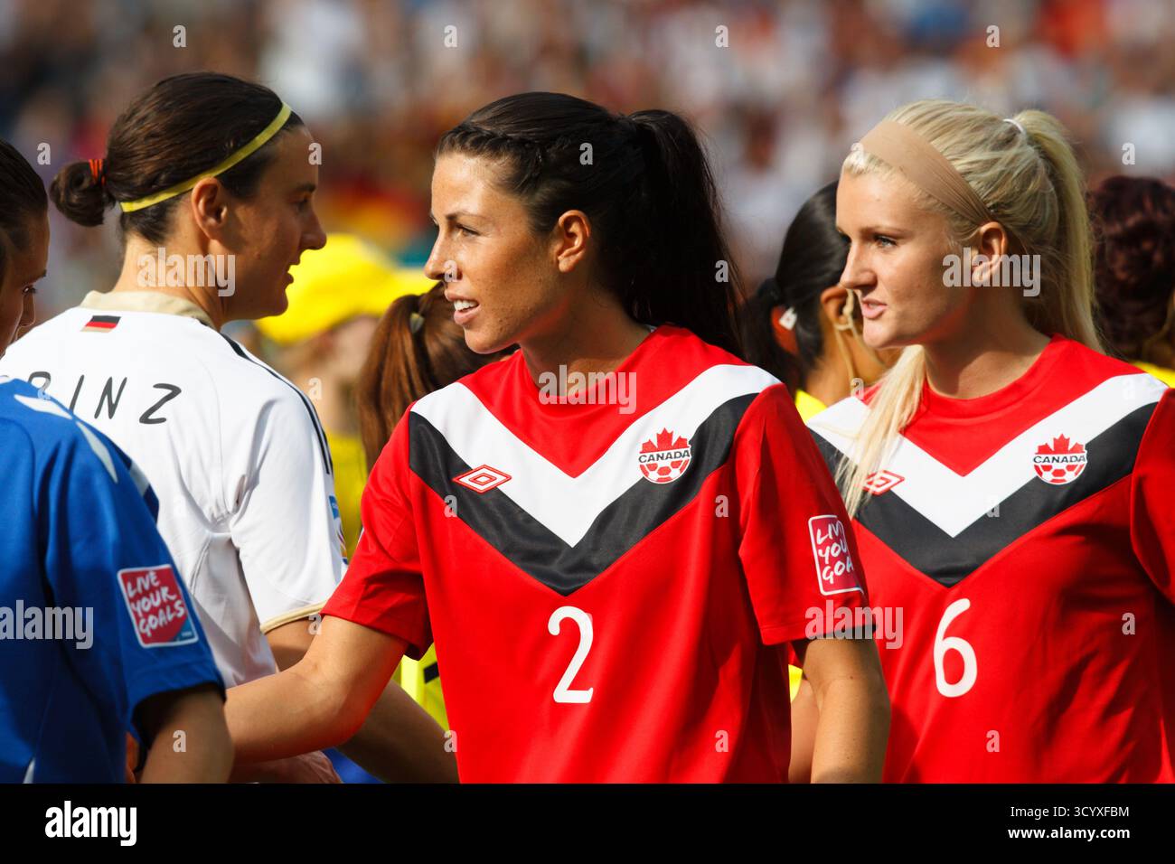 BERLINO - GIUGNO 26: Le giocatrici canadesi Emily Zurrer (2) e Kaylyn Kyle (6) stringono la mano ai giocatori tedeschi prima del calcio d'inizio della partita di apertura del torneo di calcio della Coppa del mondo femminile FIFA il 26 giugno 2011 all'Olympiastadion di Berlino, Germania. Solo per uso editoriale. Uso commerciale vietato. (Fotografia di Jonathan Paul Larsen / Diadem Images) Foto Stock BERLINO - GIUGNO 26: Le giocatrici canadesi Emily Zurrer (2) e Kaylyn Kyle (6) stringono la mano ai giocatori tedeschi prima del calcio d'inizio della partita di apertura del torneo di calcio della Coppa del mondo femminile FIFA il 26 giugno 2011 all'Olympiastadion di Berlino, Germania. Solo per uso editoriale. Uso commerciale vietato. (Fotografia di Jonathan Paul Larsen / Diadem Images) Foto Stock