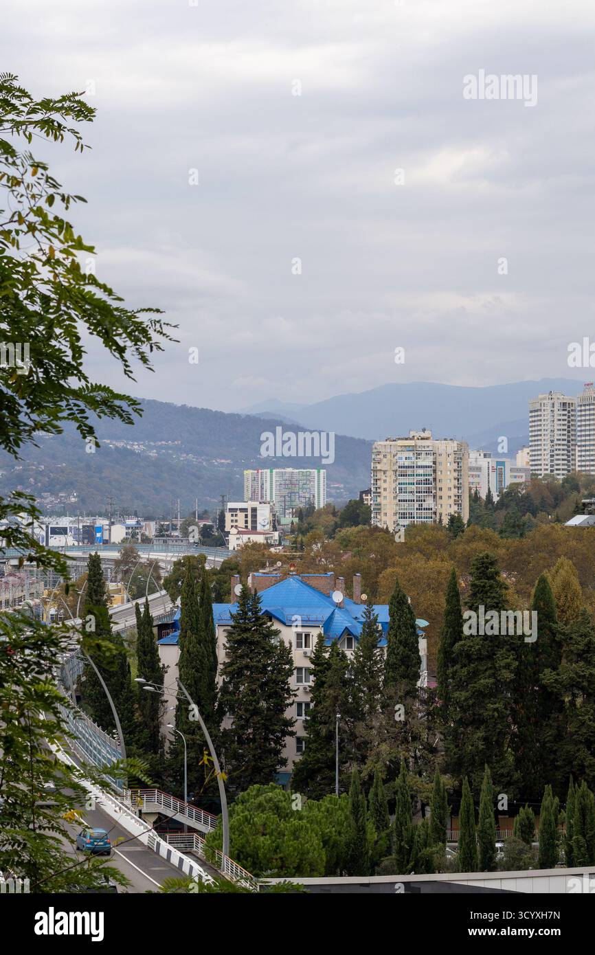 Città di montagna con tetti blu. Vista panoramica degli appartamenti e degli edifici dal tetto blu accoccolati sulle montagne, con cipressi che punteggiano la scena sottostante Foto Stock