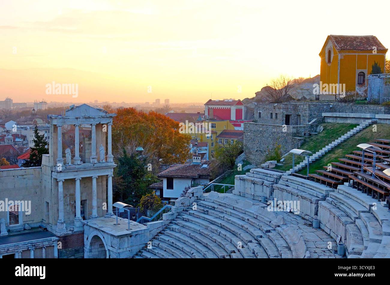 Paesaggio urbano autunnale con antiche rovine teatrali al tramonto a Plovdiv, Bulgaria Foto Stock