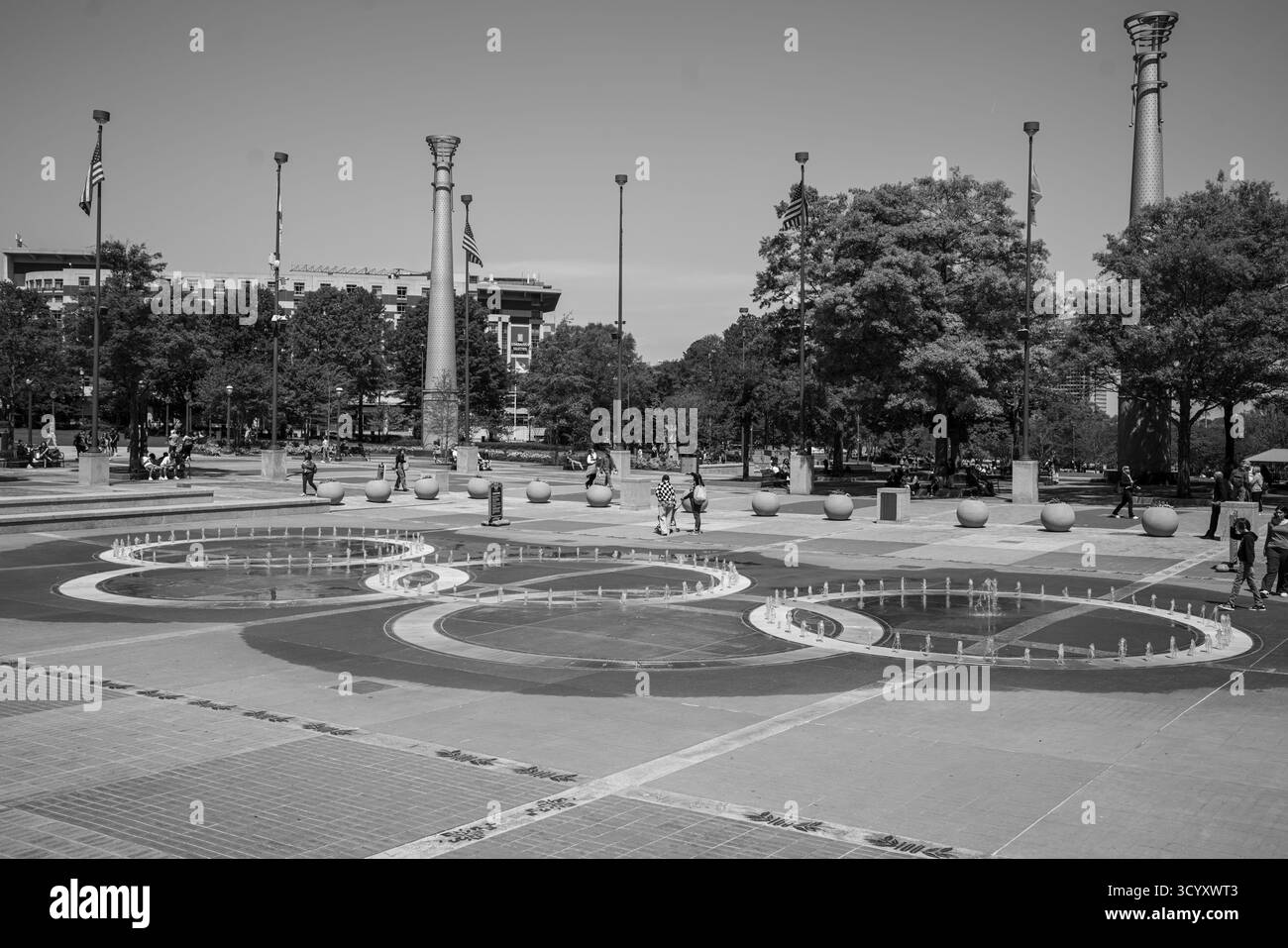 I visitatori si riuniscono intorno all'iconica Fontana degli anelli al Centennial Olympic Park in un chiaro pomeriggio primaverile in bianco e nero Foto Stock