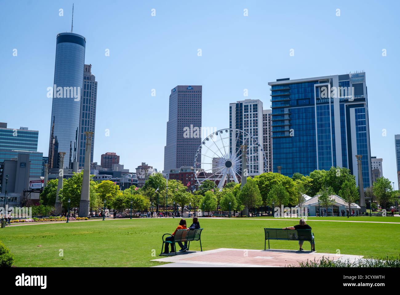 Vista del centro di Atlanta dal Centennial Olympic Park con la ruota panoramica SkyView, i moderni grattacieli e i visitatori che si rilassano in una giornata di sole Foto Stock