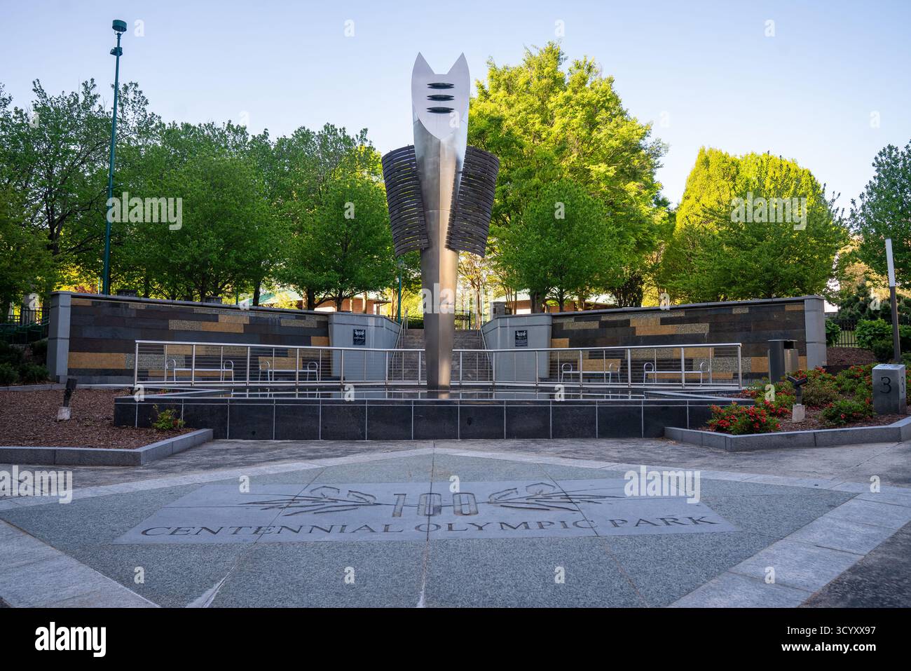 Un'ampia vista della piazza d'ingresso al Centennial Olympic Park, caratterizzata dalla scultura della torcia in acciaio inossidabile e dal design in pietra incisa Foto Stock