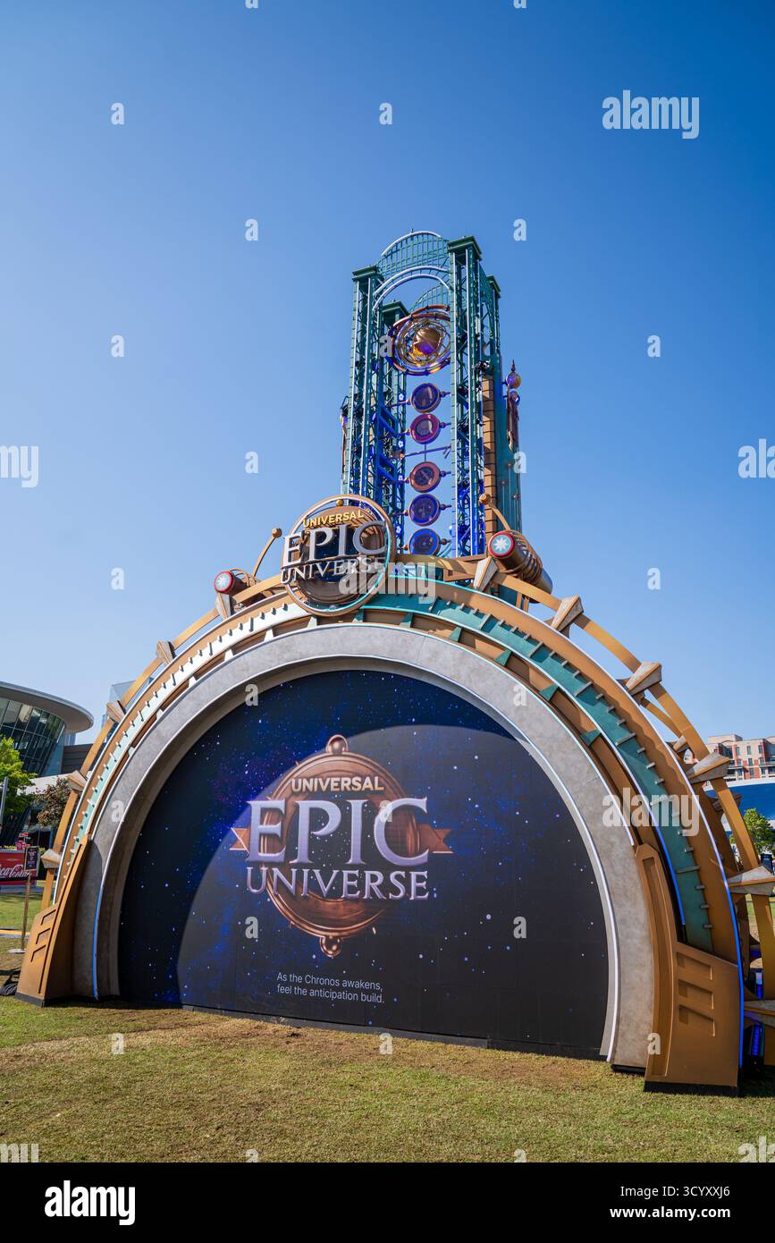 Una grande mostra promozionale del parco a tema Universal Epic Universe si trova sul World of Coca-Cola Grounds, con una torre futuristica sotto un cielo blu Foto Stock