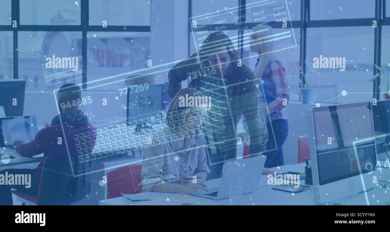 Parlare di donna in camicetta e pantaloni con un collega di sesso maschile che esamina il laptop in ufficio con gli impianti Foto Stock