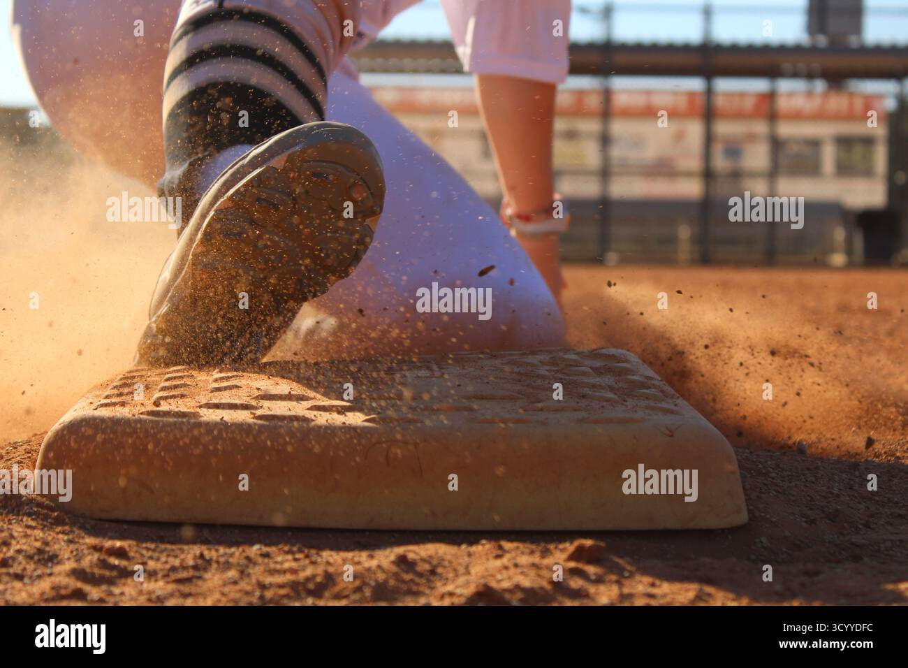 Primo piano di Softball Runner che tocca la base durante la partita Foto Stock