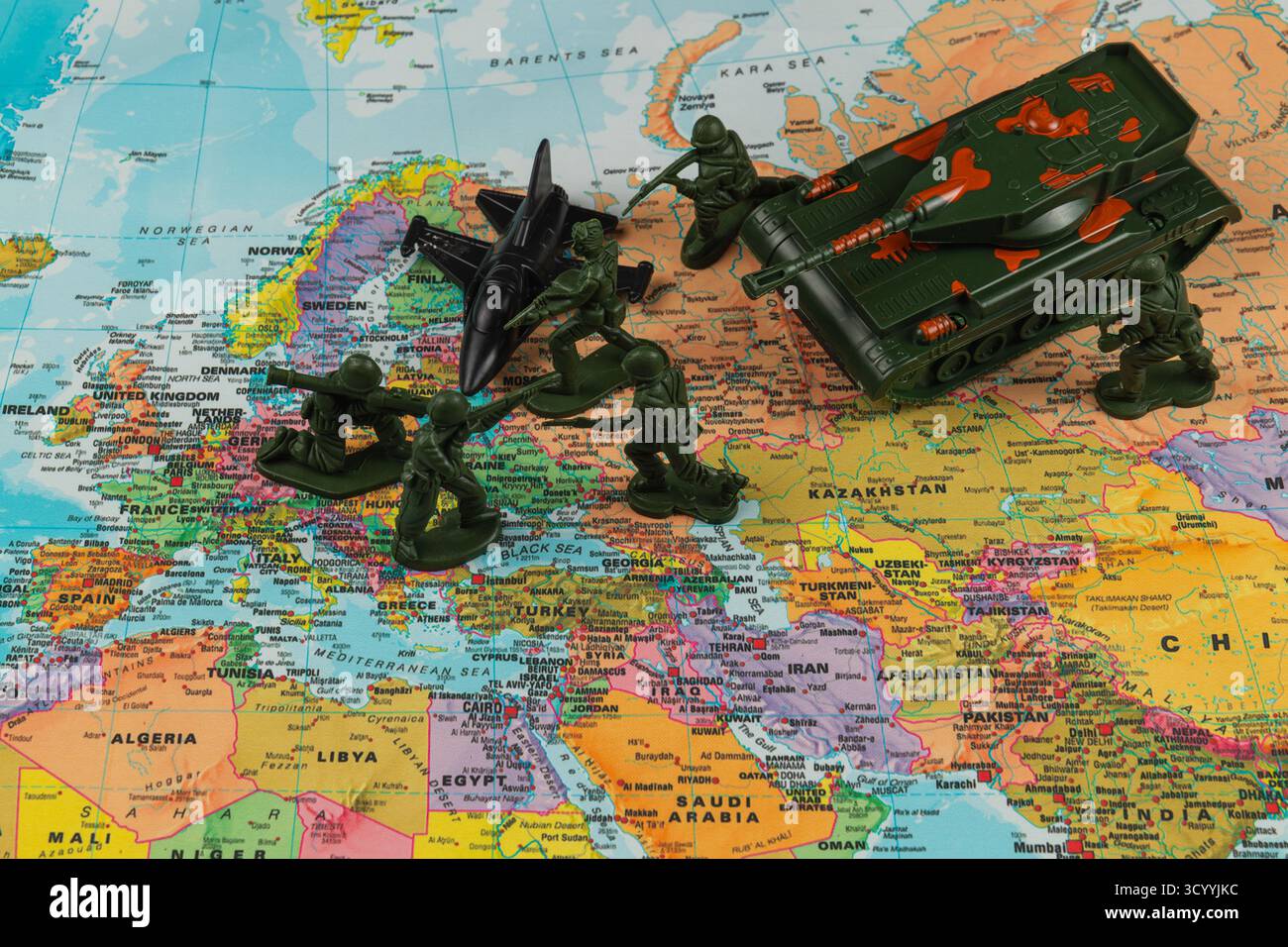 I soldati e i veicoli giocattolo sono esposti su una vivace mappa dell'Europa, creando una scena giocosa di strategia militare e immaginazione in un ambiente colorato Foto Stock I soldati e i veicoli giocattolo sono esposti su una vivace mappa dell'Europa, creando una scena giocosa di strategia militare e immaginazione in un ambiente colorato Foto Stock