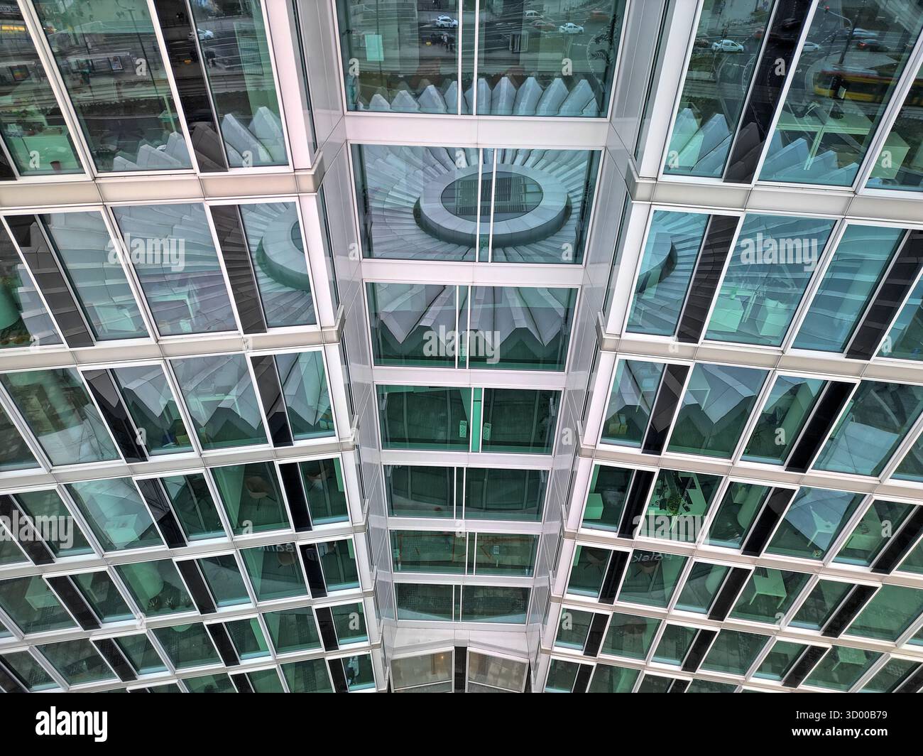 Ripresa ravvicinata di un drone che cattura le finestre a strati e riflettenti di un alto edificio a Varsavia, con riflessi dell'iconica Rotonda PKO nel Foto Stock