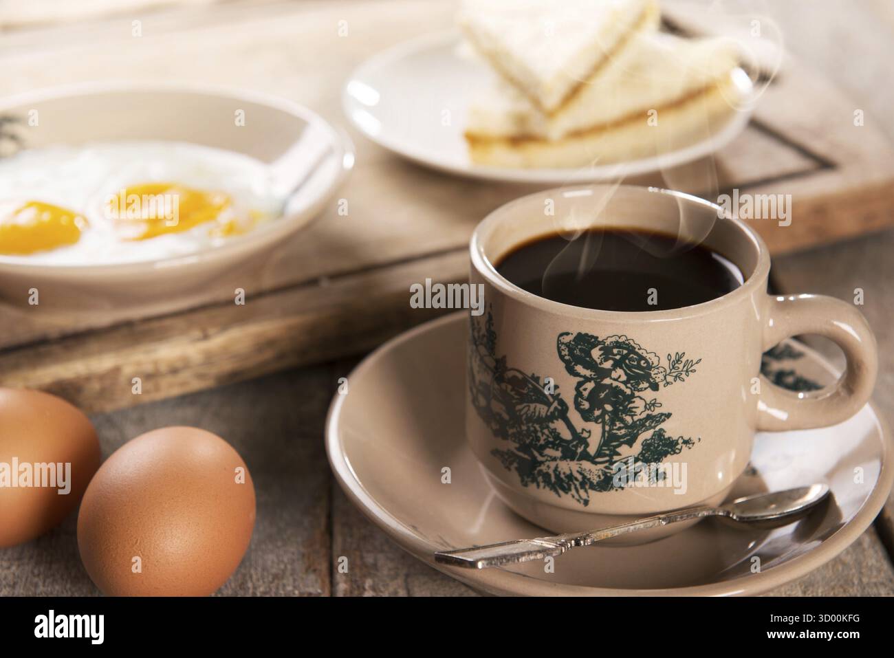 Caffè tradizionale cinese di Singapore in tazze e piattini vintage con colazione. Il frattale sulla coppa è una stampa generica. Messa a fuoco soffusa per un'atmosfera spettacolare Foto Stock