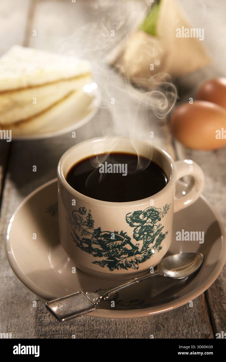 Tradizionale caffè malese in stile kopitiam e colazione con luce del sole mattutina. Il frattale sulla coppa è una stampa generica. Impostazione della messa a fuoco morbida con un effetto spettacolare Foto Stock