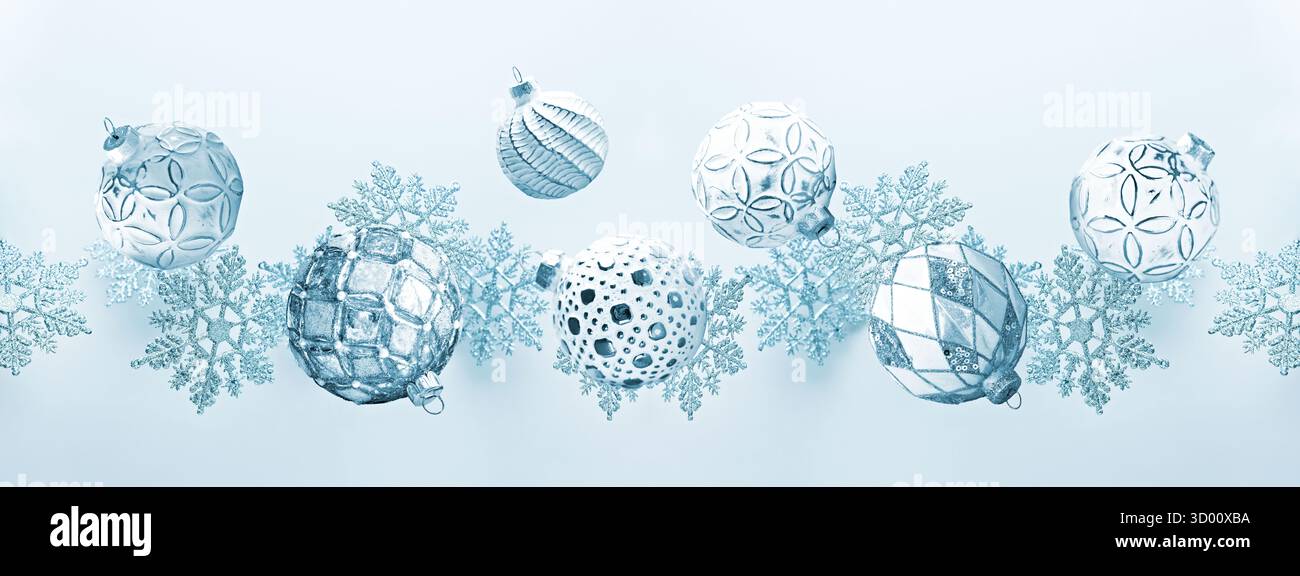 Ornamenti in argento e bianco con fiocchi di neve blu su sfondo blu Foto Stock