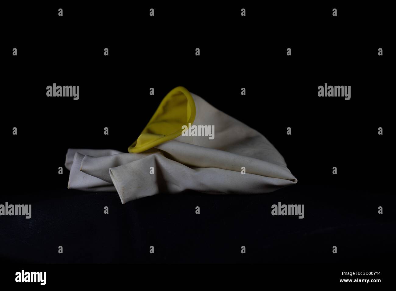 guanto in gomma monouso per lavaggio sporco isolato su sfondo nero Foto Stock