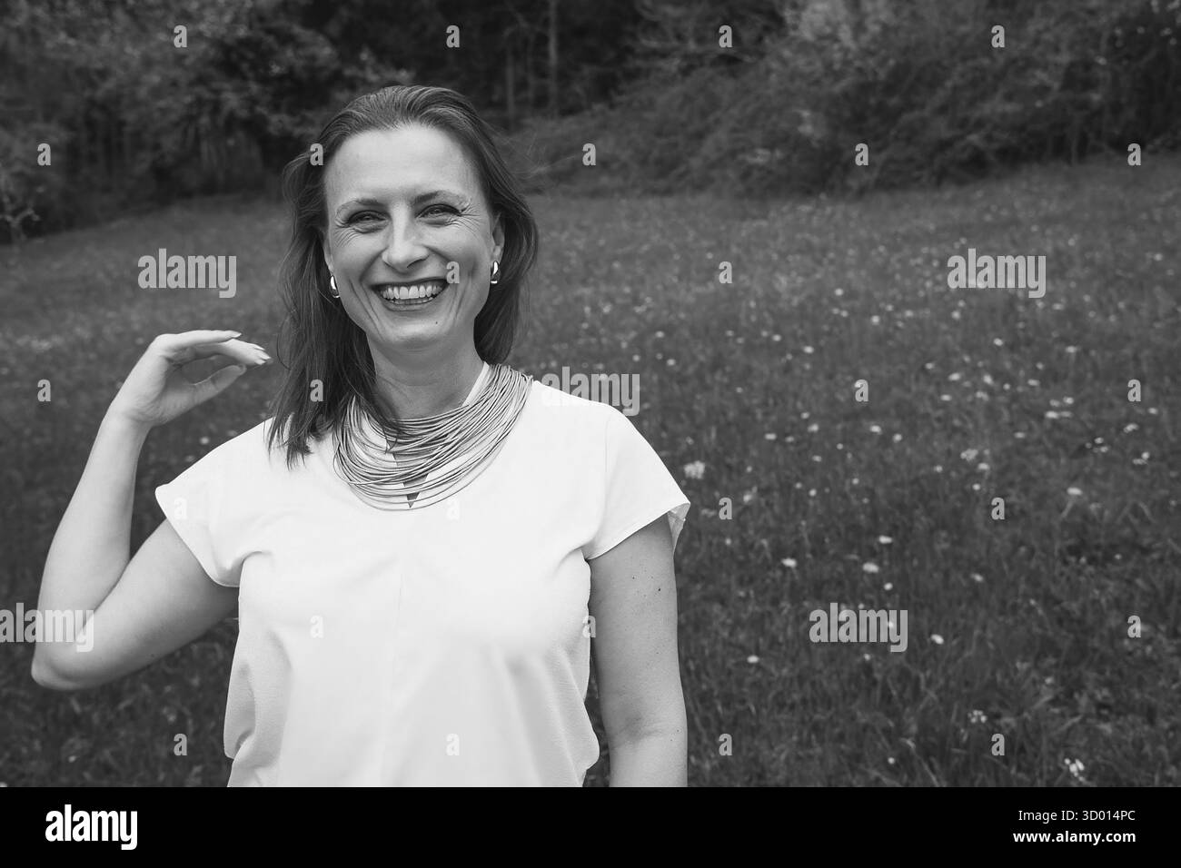 Donna felice di mezza età che ama la natura e si abbraccia nel campo primaverile. Concetto di auto-amore, salute femminile, equilibrio emotivo, consapevolezza, An Foto Stock