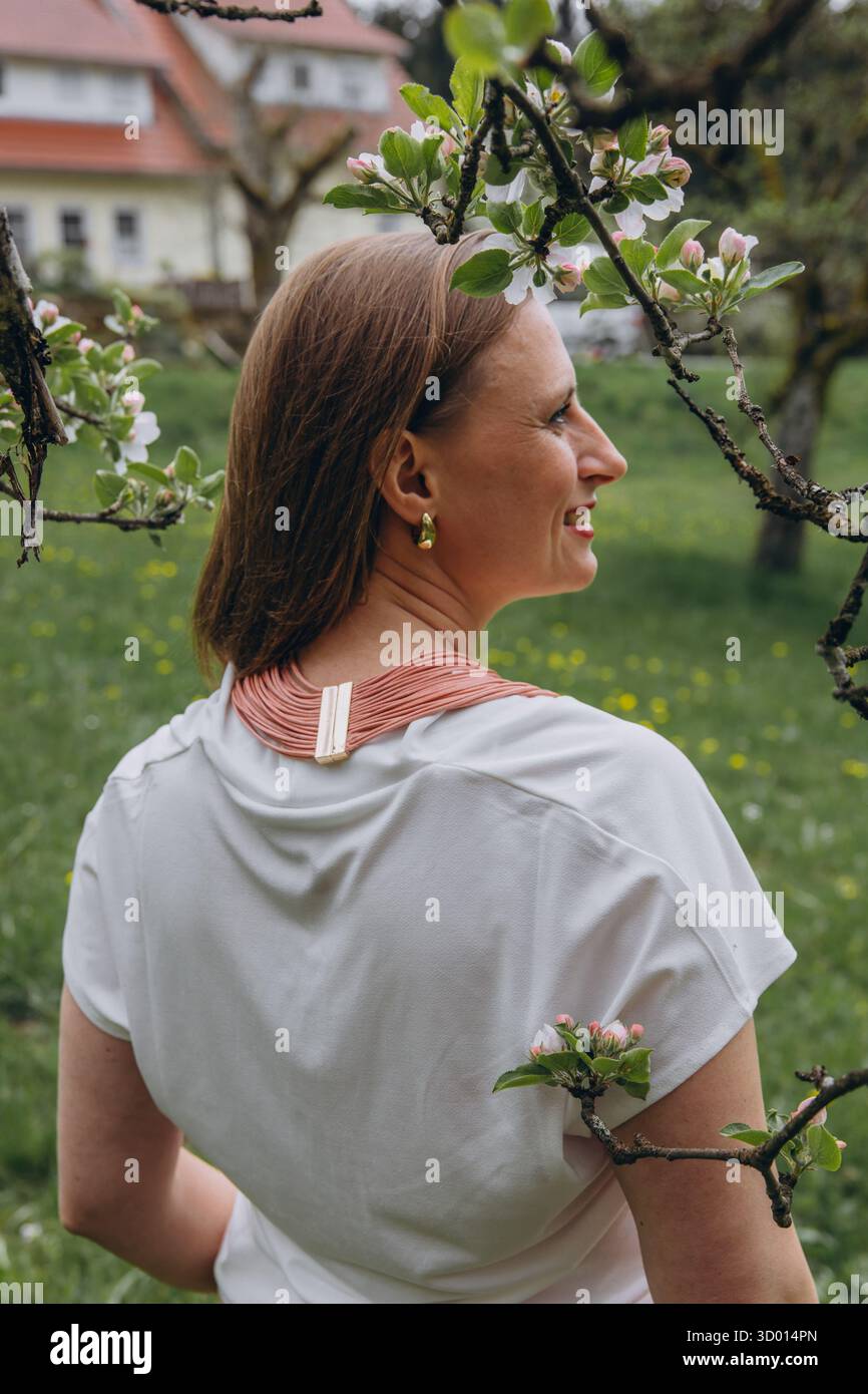 Donna felice di mezza età che ama la natura e si abbraccia nel campo primaverile. Concetto di auto-amore, salute femminile, equilibrio emotivo, consapevolezza, An Foto Stock