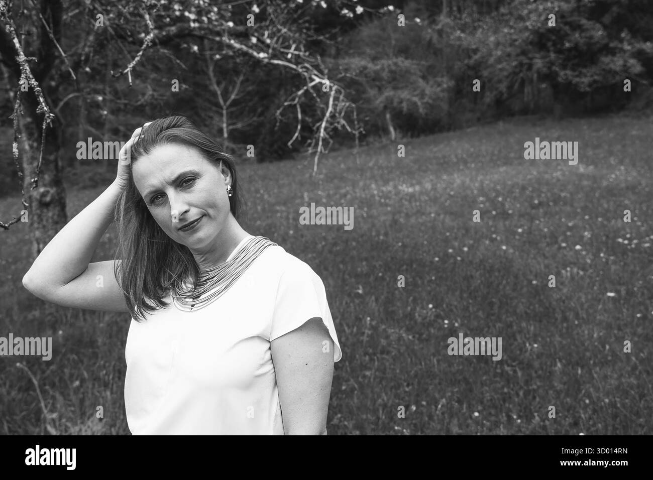 Donna felice di mezza età che ama la natura e si abbraccia nel campo primaverile. Concetto di auto-amore, salute femminile, equilibrio emotivo, consapevolezza, An Foto Stock