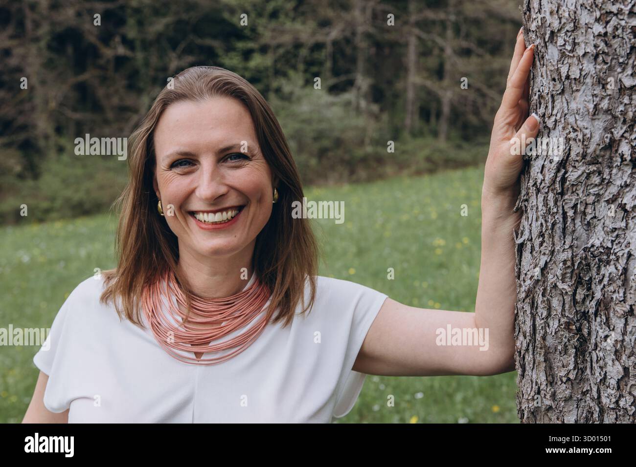 Donna felice di mezza età che ama la natura e si abbraccia nel campo primaverile. Concetto di auto-amore, salute femminile, equilibrio emotivo, consapevolezza, An Foto Stock