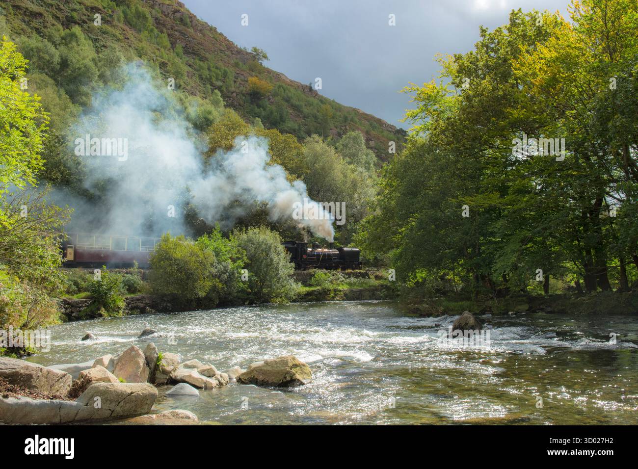 Treno a vapore che trasporta carrozze accanto all'Afon Glaslyn poco prima di scendere attraverso l'Aber Glaslyn Pass, Welsh Highland Railway NG16 Foto Stock