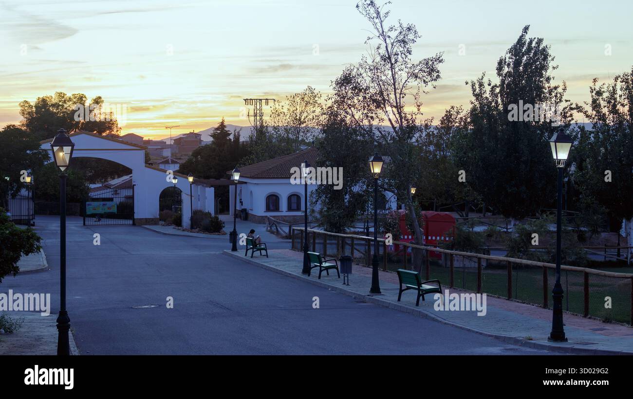 Ingresso a un campeggio rurale con panche e lampioni a Humilladero, Málaga, Spagna al tramonto Foto Stock
