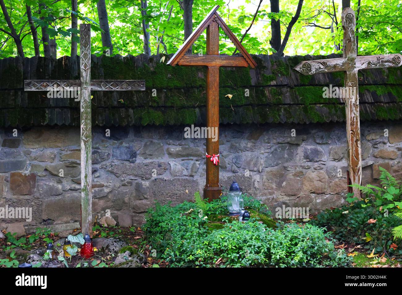 Croci rustiche in legno in un tranquillo cimitero di Woodland Foto Stock