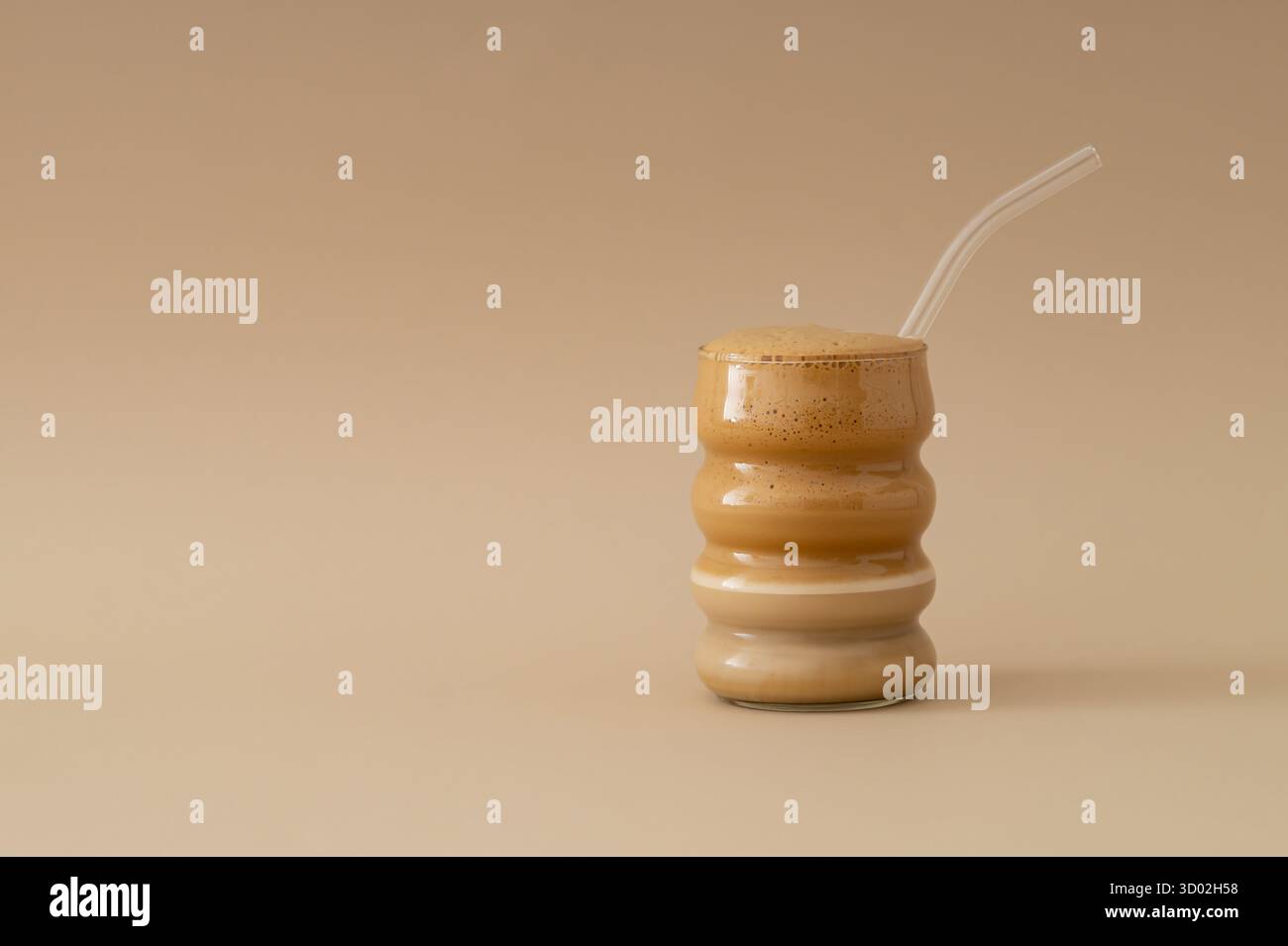 Tazza di caffè in vetro su sfondo color crema pastello con spazio per le copie. Concetto di caffè minimale. Foto Stock