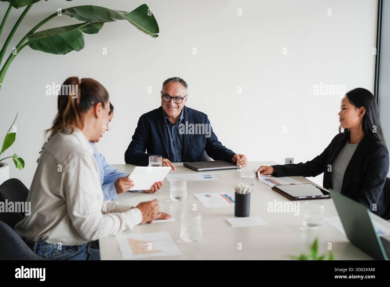 Uomini d'affari multigenerazionali che condividono idee all'interno dell'ufficio aziendale - colleghi multirazziali che discutono di un nuovo progetto finanziario Foto Stock