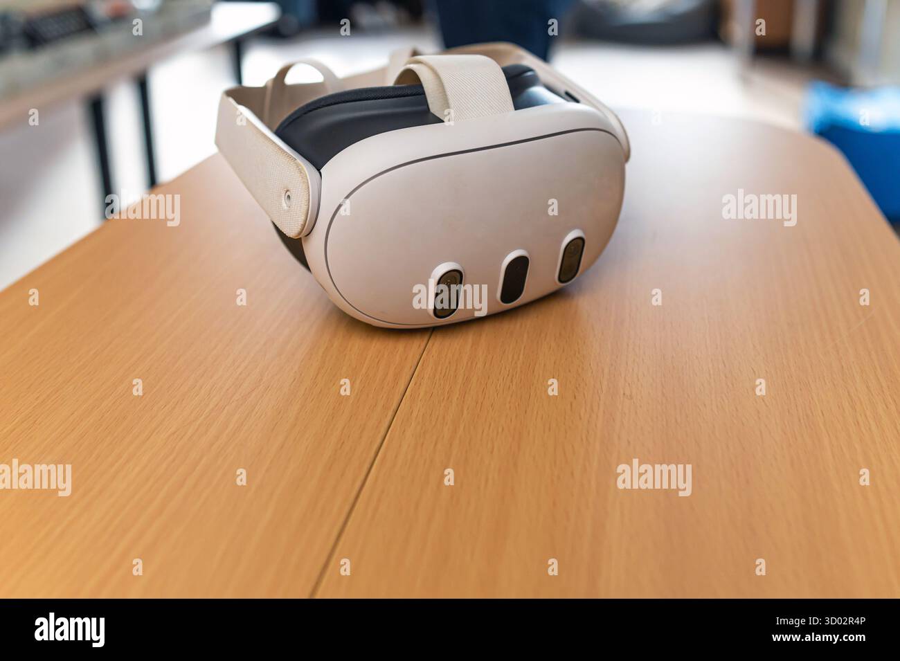 Un visore per la realtà virtuale poggia su un tavolo di legno, pronto per esperienze di gioco coinvolgenti. Foto Stock