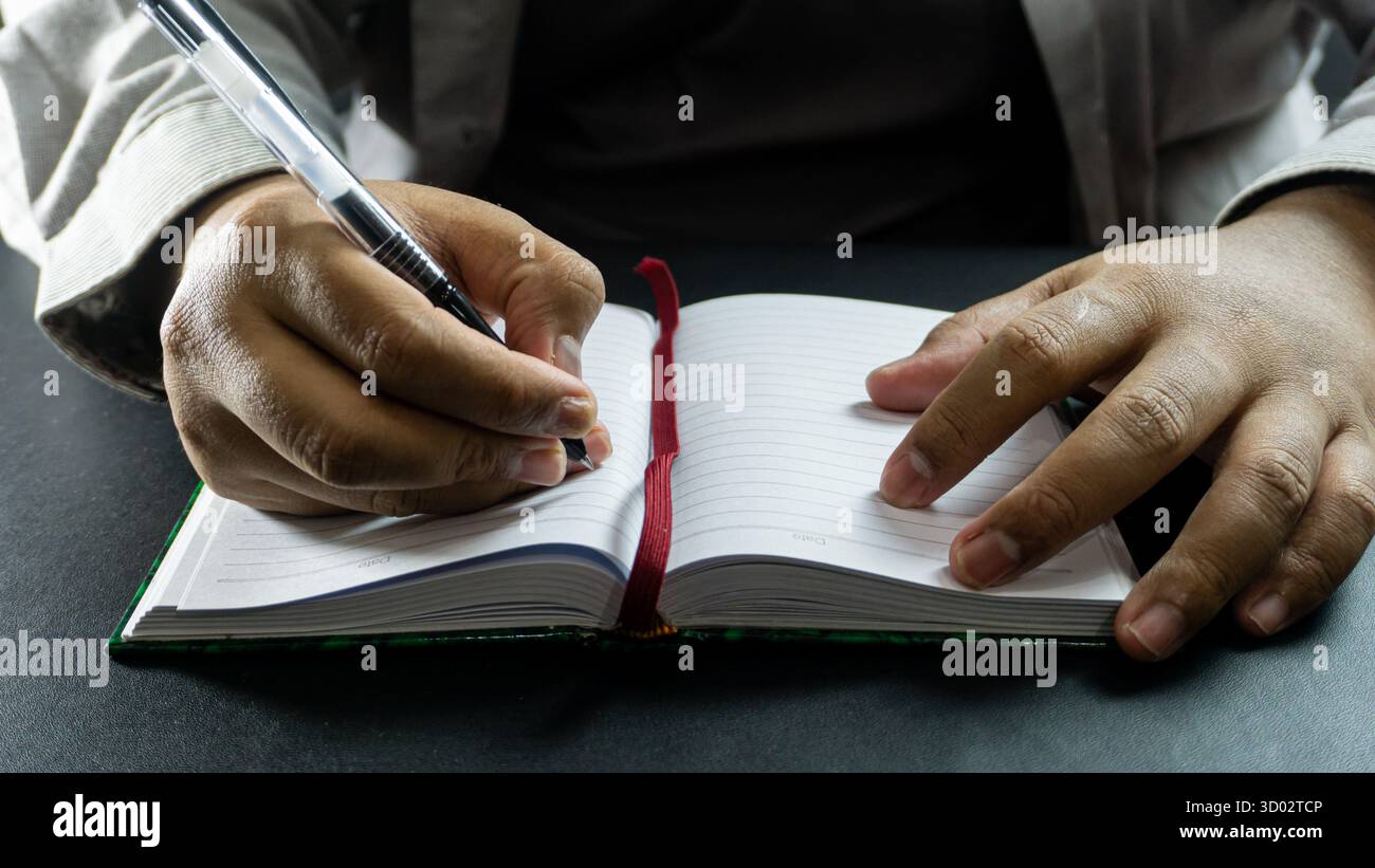 Quaderno e penna maschili pronti per scrivere, vista frontale con camicia visibile, pianificazione informale o momento di pubblicazione con composizione minima Foto Stock