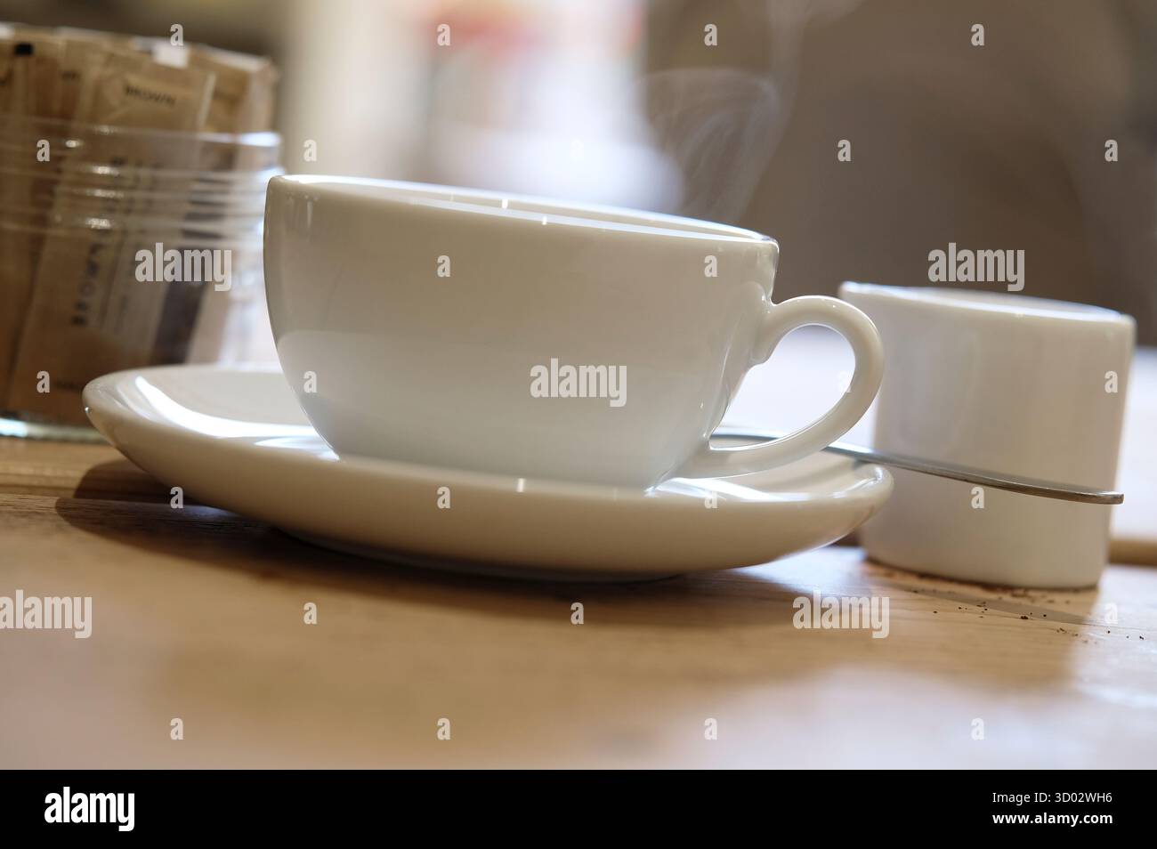 tazza da caffè bianca e piattino con caraffa del latte e vaso dello zucchero Foto Stock