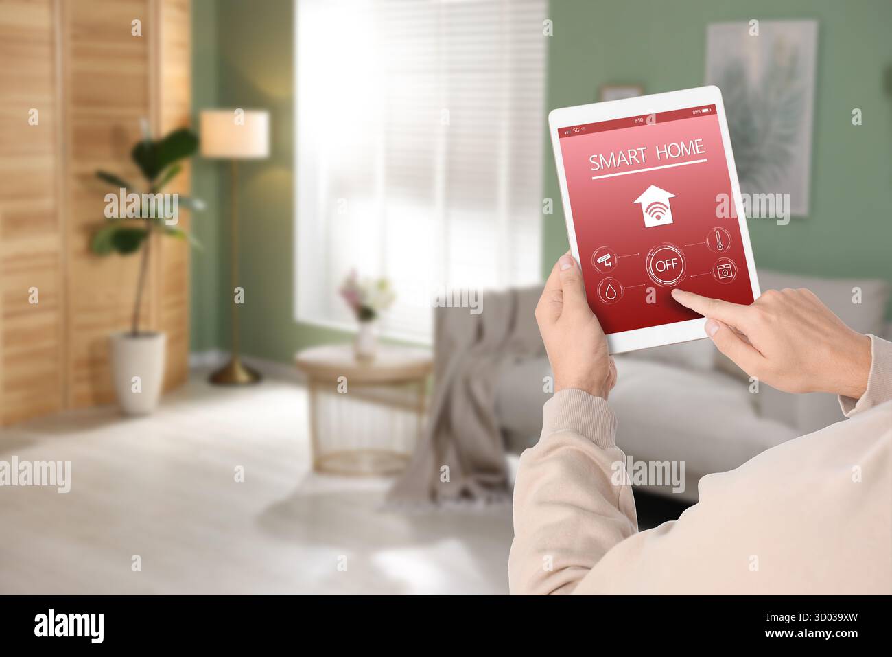 Uomo che utilizza un'app per la casa intelligente su un tablet per controllare le caratteristiche della casa e per un primo piano Foto Stock