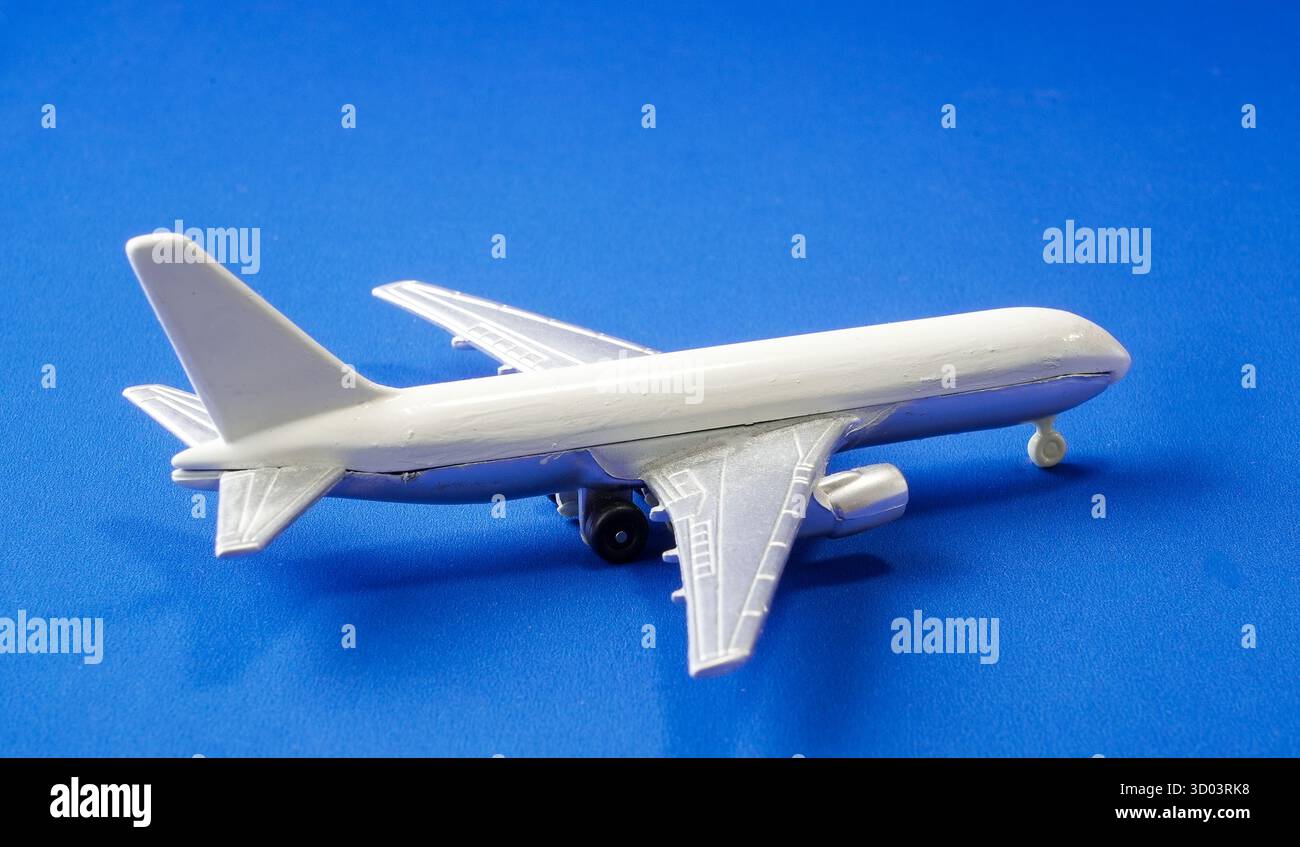 Un modello dettagliato di aeroplano si trova su una superficie blu brillante, evidenziando le complesse caratteristiche del design aeronautico. Questa rappresentazione cattura l'essen Foto Stock