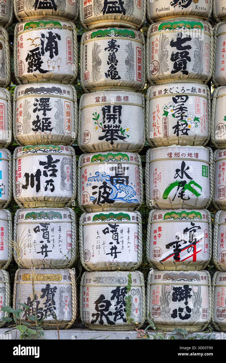 Botti di sake del periodo Edo che mostrano calligrafia, modelli e tradizione culturale in un santuario shintoista Foto Stock
