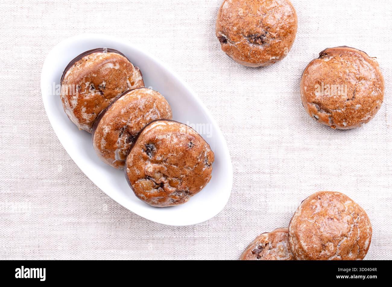 Pan di zenzero alla frutta, tradizionale lebkuchen tedesco in una ciotola bianca, su lino. Biscotti alle spezie natalizie, con frutta candita e glassa di zucchero. Foto Stock