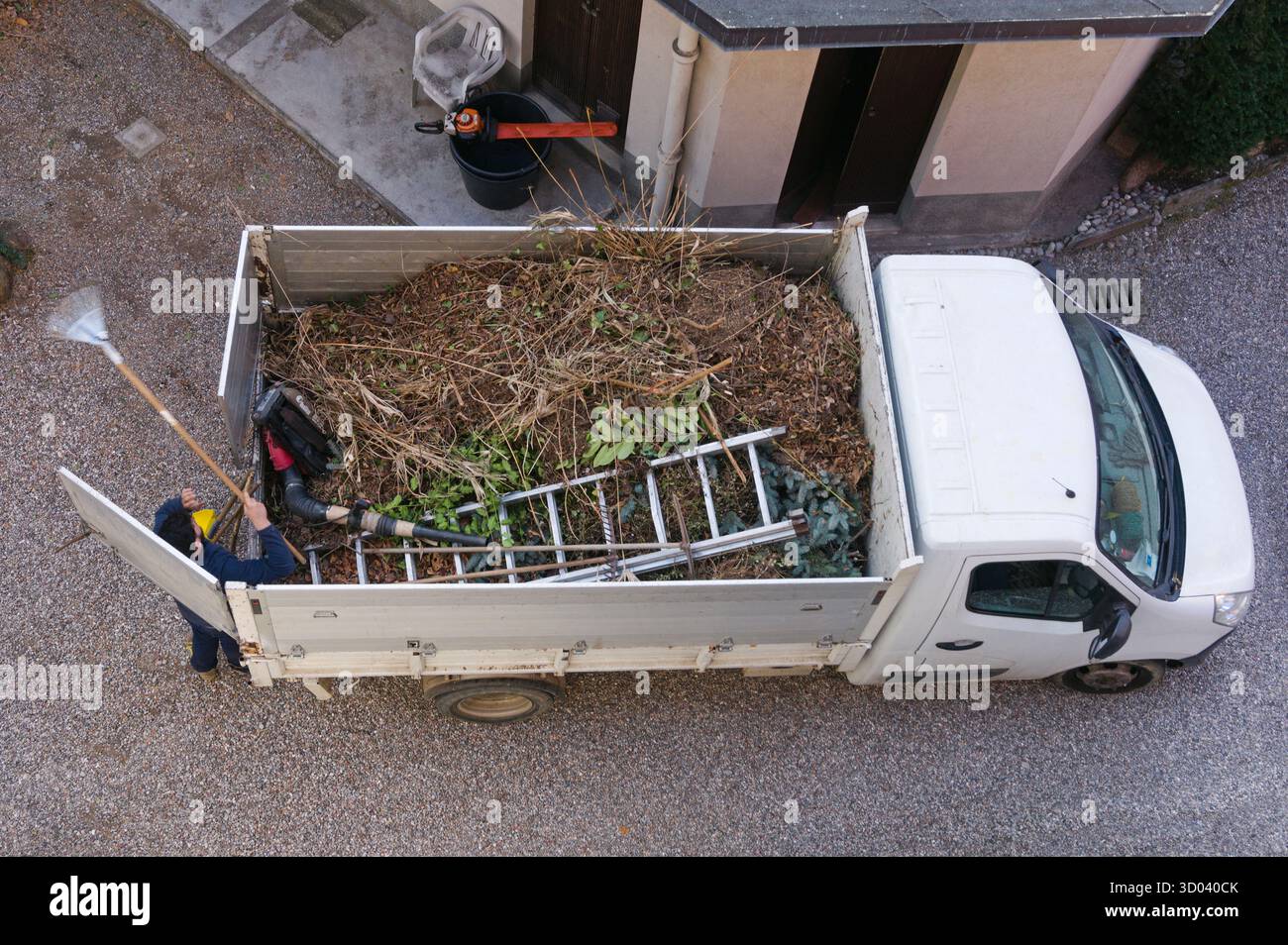 vista dall'alto dei rami pieni di camion e delle foglie asciutte dopo la potatura e la pulizia di un giardino Foto Stock