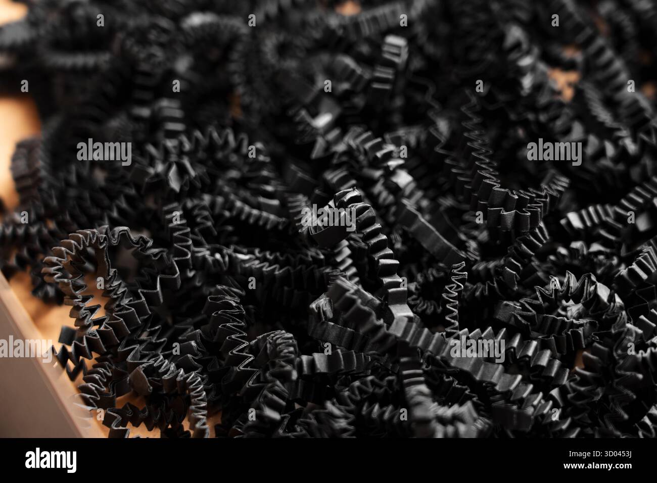 Riempitivo triturato in carta nera in una scatola regalo di cartone vuota Foto Stock