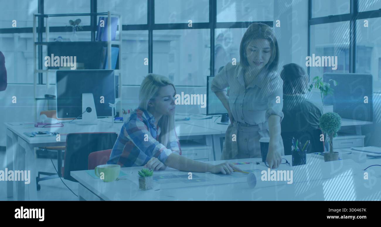 Donna che indossa camicette e pantaloni appoggiati sulla scrivania in ufficio, con documenti e piante Foto Stock