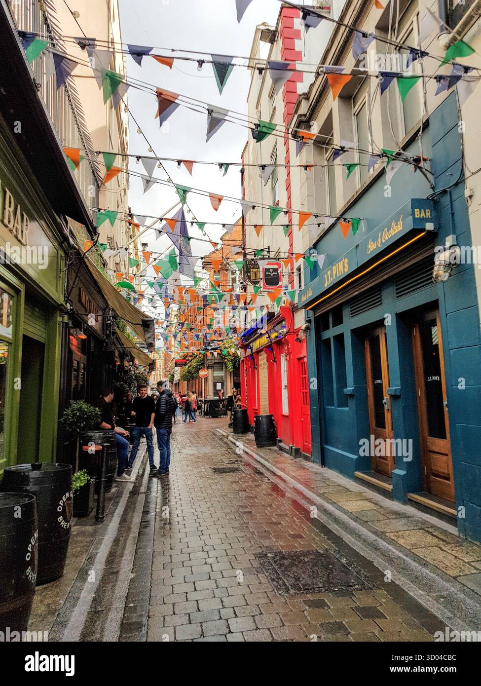 Dame Lane a Dublino, Irlanda, in un pomeriggio umido, piovoso e coperto. Le bandiere fiancheggiano la strada dove sedersi fuori in un pub a bere qualcosa. Foto Stock Dame Lane a Dublino, Irlanda, in un pomeriggio umido, piovoso e coperto. Le bandiere fiancheggiano la strada dove sedersi fuori in un pub a bere qualcosa. Foto Stock