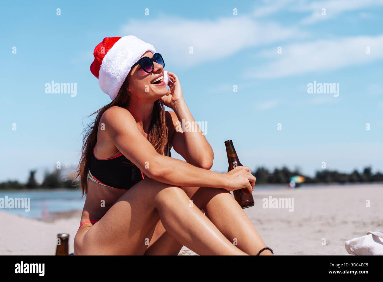 Donna moderna che festeggia il Natale su una spiaggia tropicale. Foto Stock