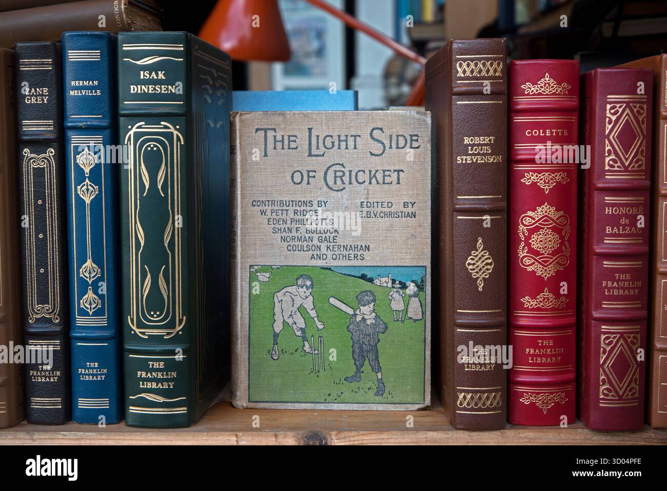 Copia vintage di 'The Light Side of Cricket', 1a edizione pubblicata nel 1898 da James Bowden, nella vetrina di una libreria di seconda mano a Edimburgo. Foto Stock