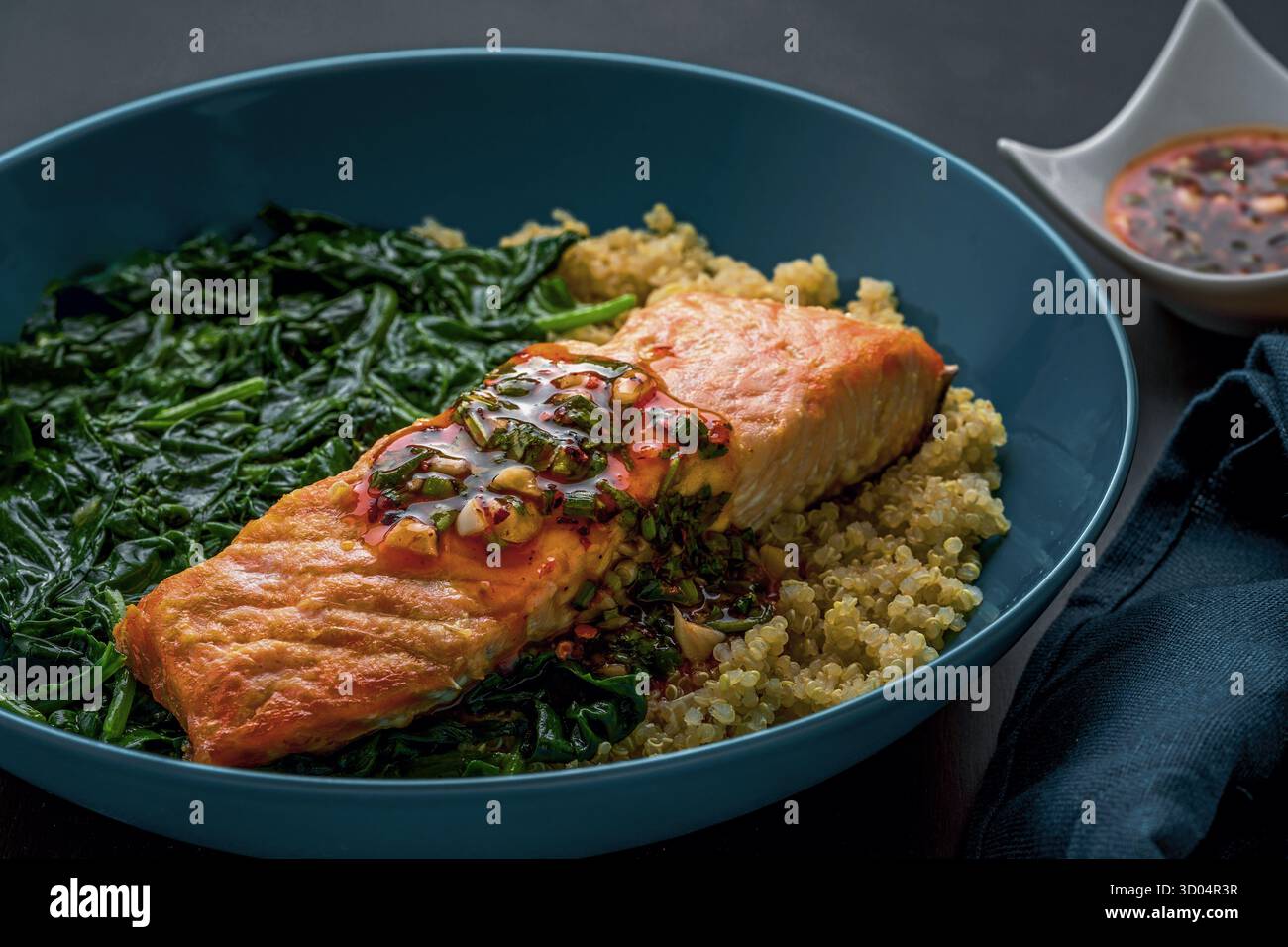 Filetto di salmone al forno sul letto di quinoa e spinaci selvaggi. Foto Stock