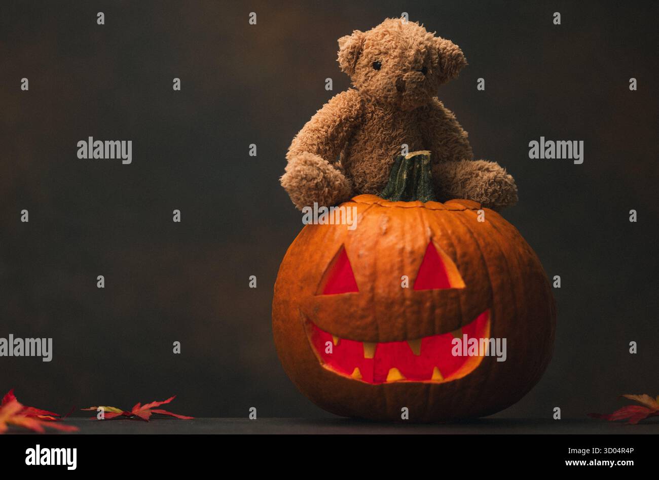 Spaventosa zucca di Halloween con occhi rossi brillanti e fumo su sfondo nero Foto Stock