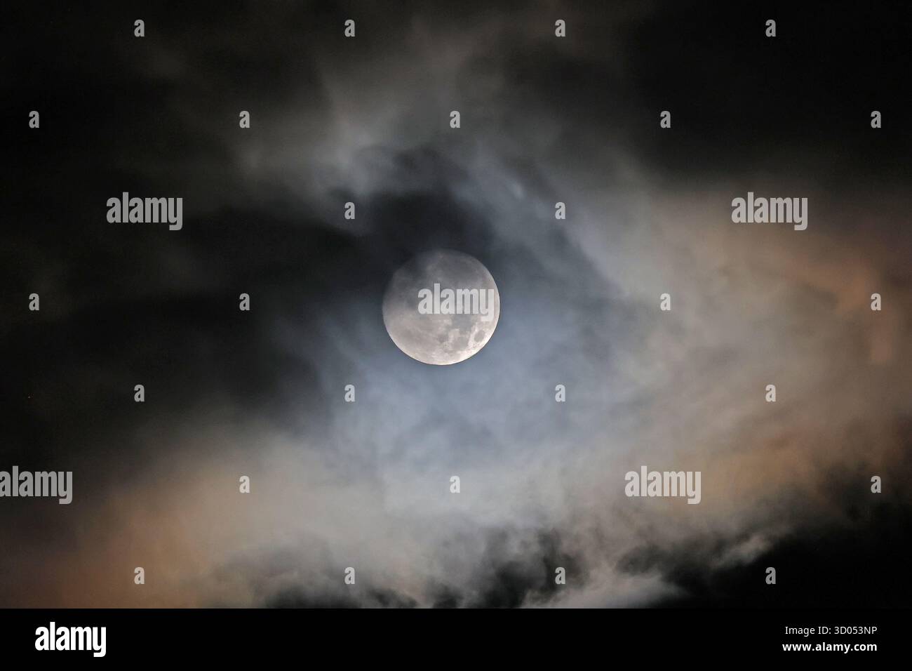 Luna piena parzialmente coperta da nuvole di notte Foto Stock