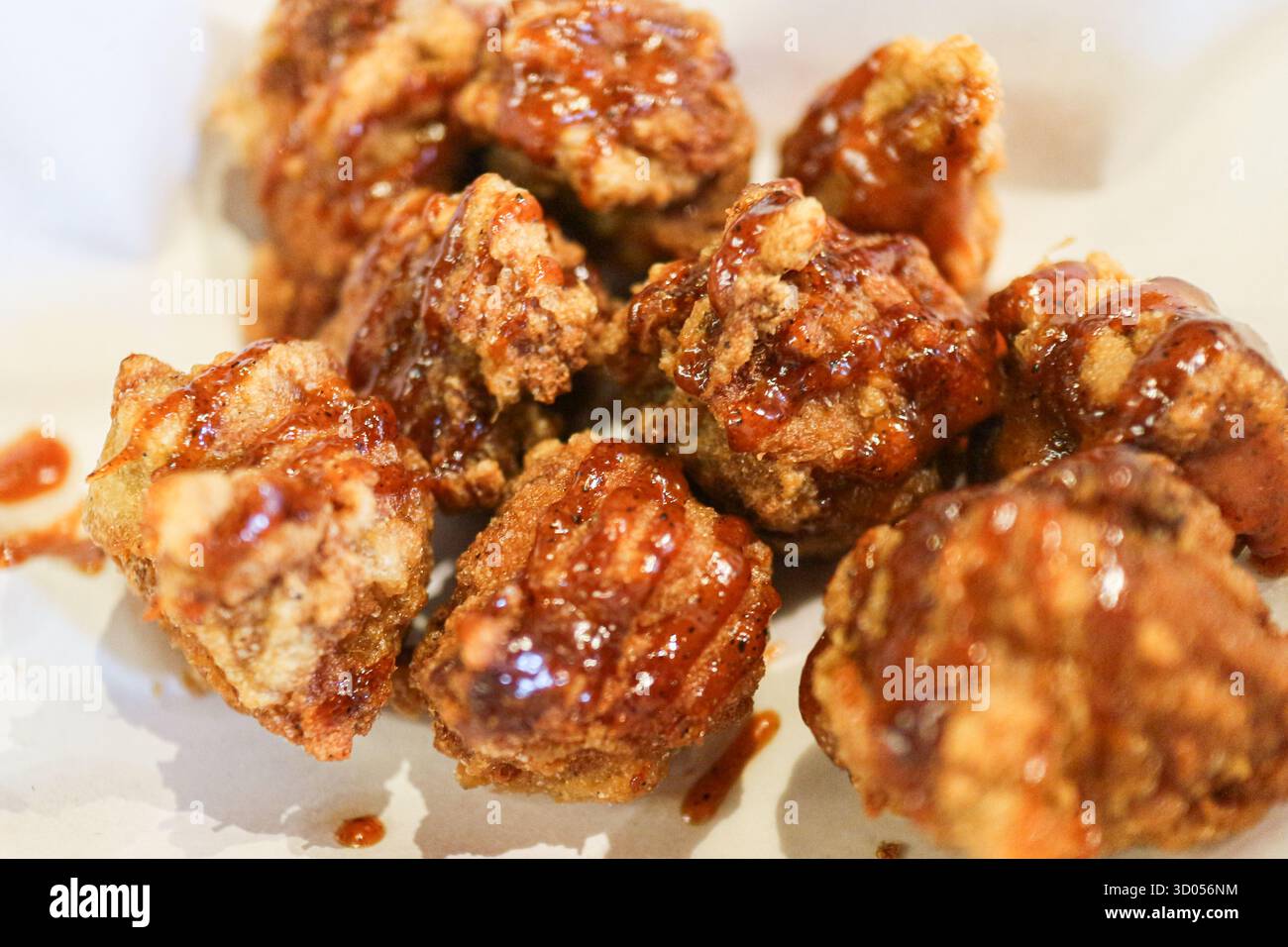 Pezzetti di Dakgangjeong (pollo fritto coreano) ricoperti da una salsa dolce e appiccicosa. Un popolare spuntino K-Food dalla consistenza croccante. Foto Stock