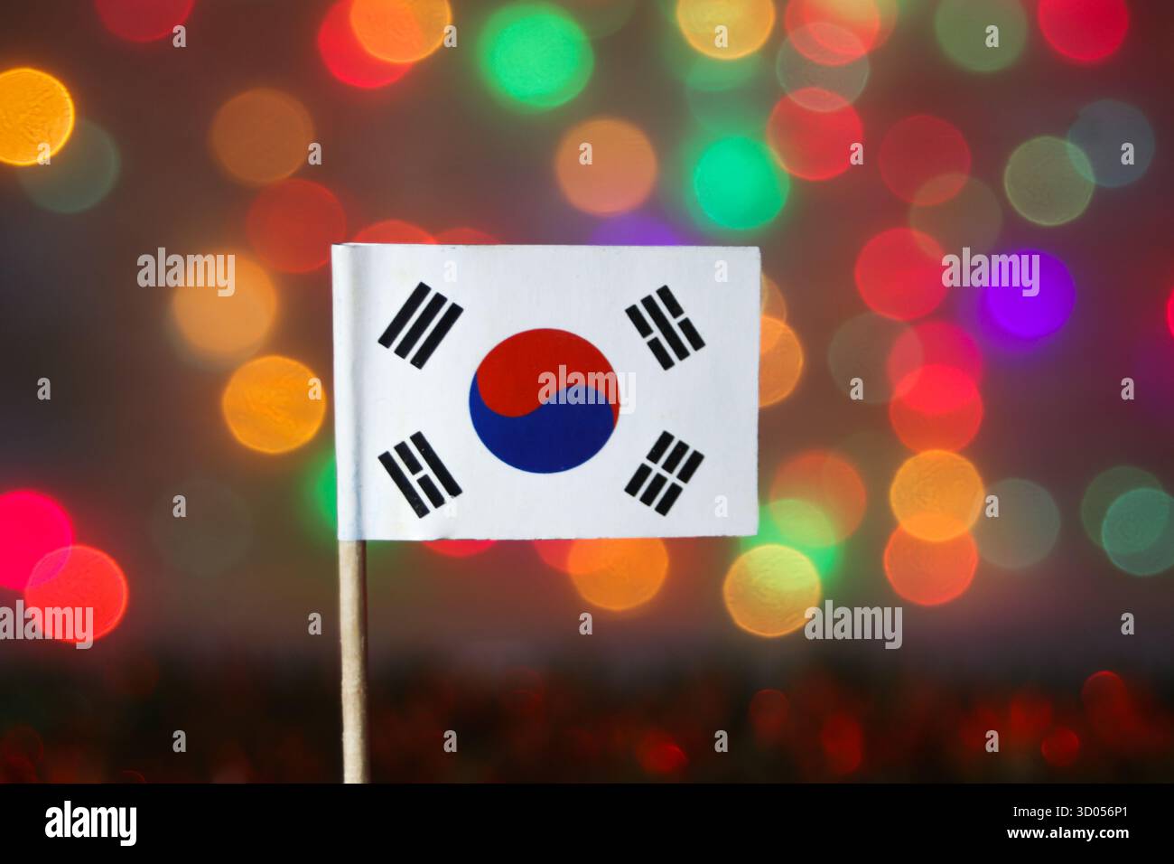 Bandiera nazionale della Corea del Sud (Taegeukgi) contro colorate luci bokeh. Cultura asiatica, tecnologia, K-Pop e temi di celebrazione nazionale. Foto Stock