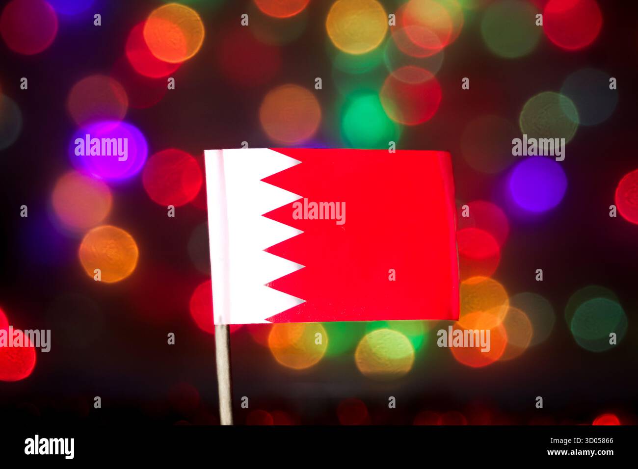 Bandiera nazionale del Bahrein contro le colorate luci bokeh. Finanza della regione del Golfo, orgoglio nazionale, commercio in Medio Oriente e media per le vacanze. Foto Stock