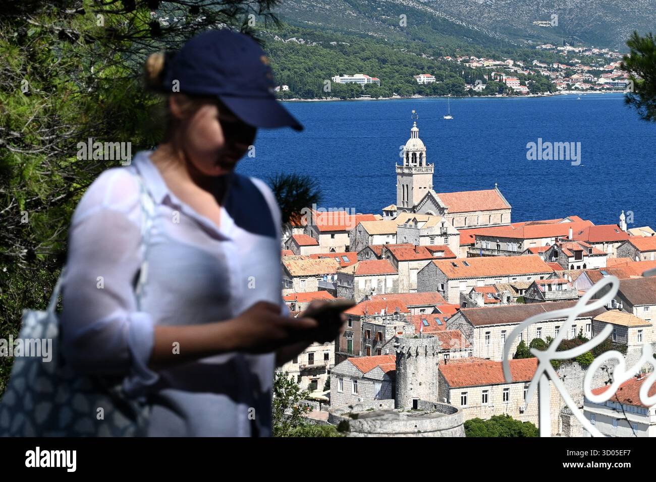 Korcula, Croazia - 26 agosto 2025: Woman at the view poit vicino alla città vecchia di Korcula in Croazia. Foto Stock