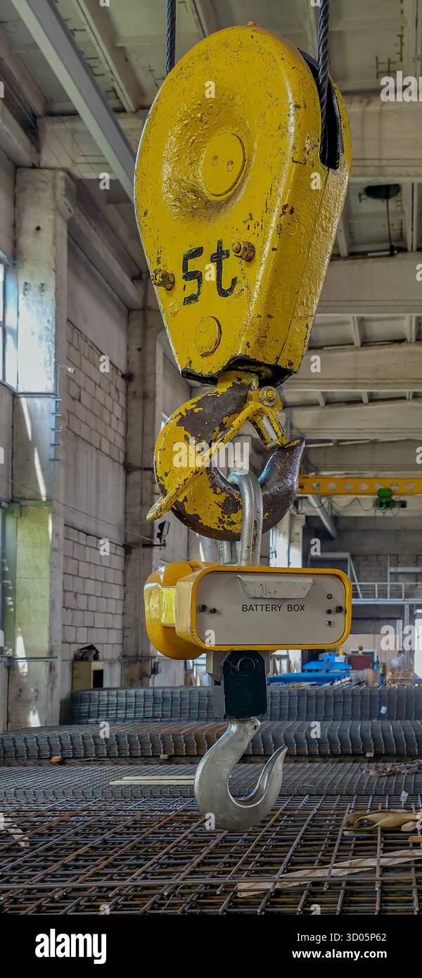 Gancio per gru industriale appeso alle funi. Interni di fabbrica per l'industria edile - Immagine stock catturata con smartphone