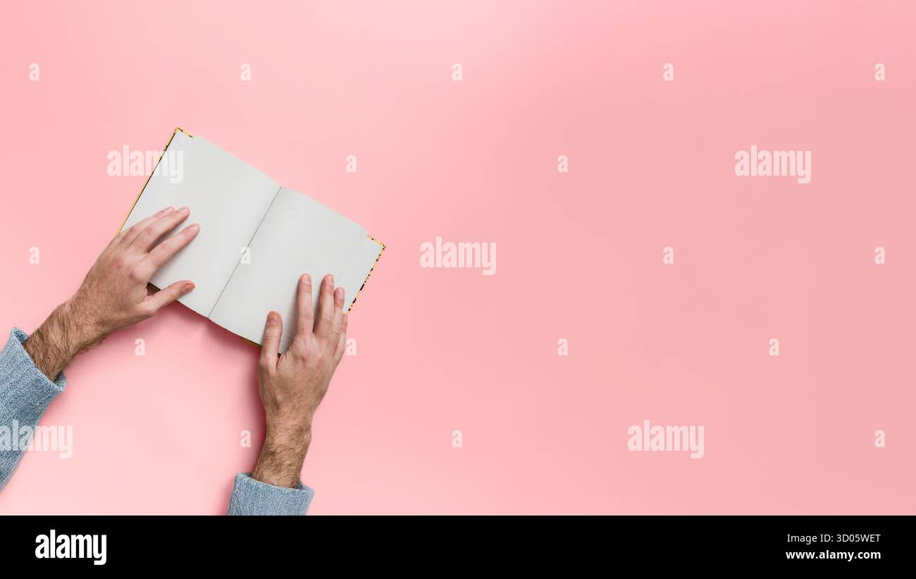 Vista dall'alto notebook bianco con apertura mani su rosa. Inserimento nel Journal e prendere appunti. Spazio di scrittura creativo. Disposizione piatta minimalista. Produttiva e stimolante Foto Stock