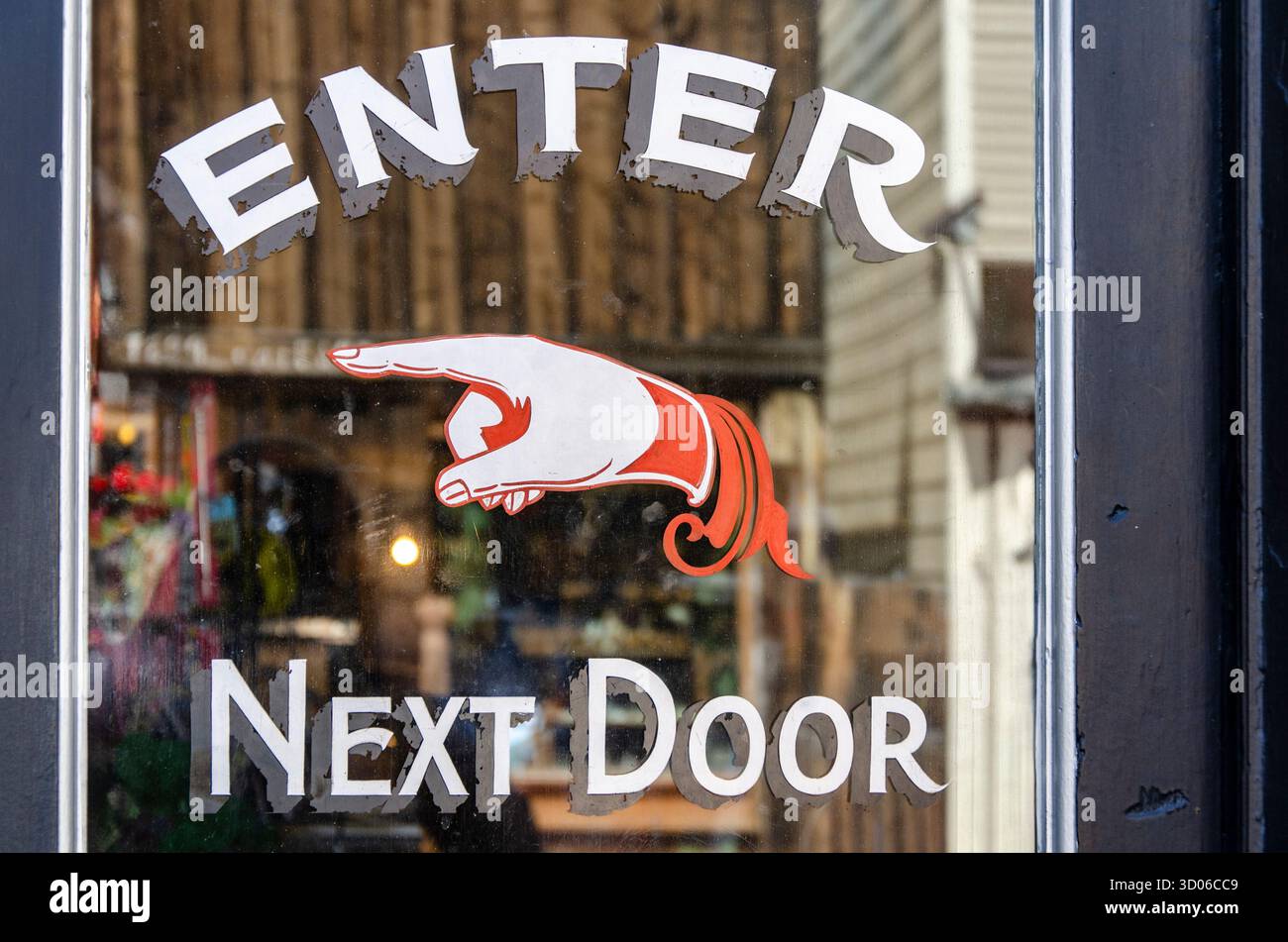 Inserire il cartello della porta successiva con una mano puntiforme rossa sulla finestra di vetro per Un punto vendita Foto Stock