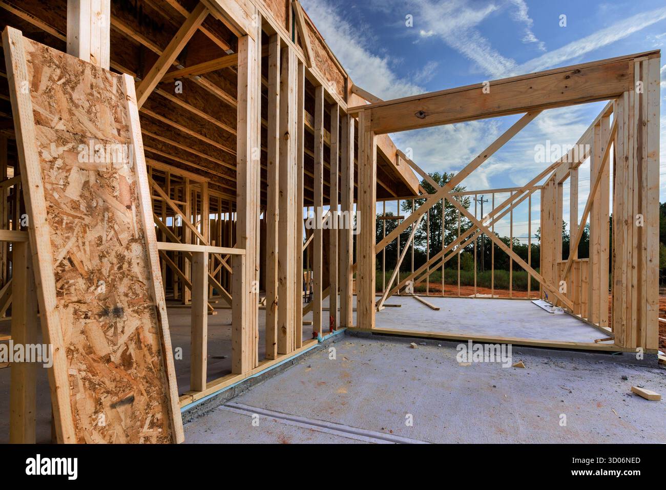 La costruzione di nuove abitazioni avanza con strutture in legno e travi erette in un quartiere tranquillo. Foto Stock